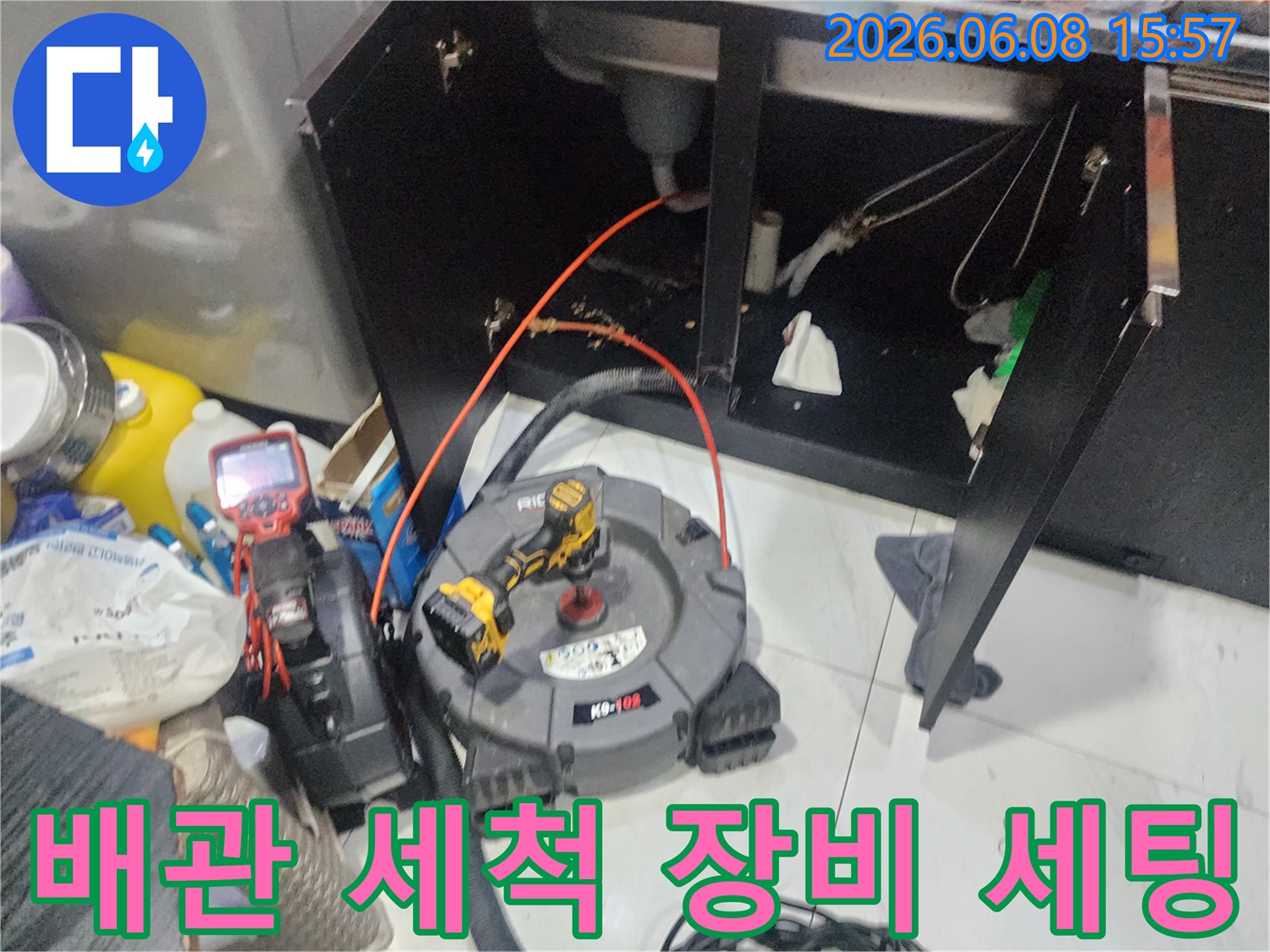 배관 스케일링을 위해 싱크대 하부장에 배치된 전문 장비와 배관 연결 모습