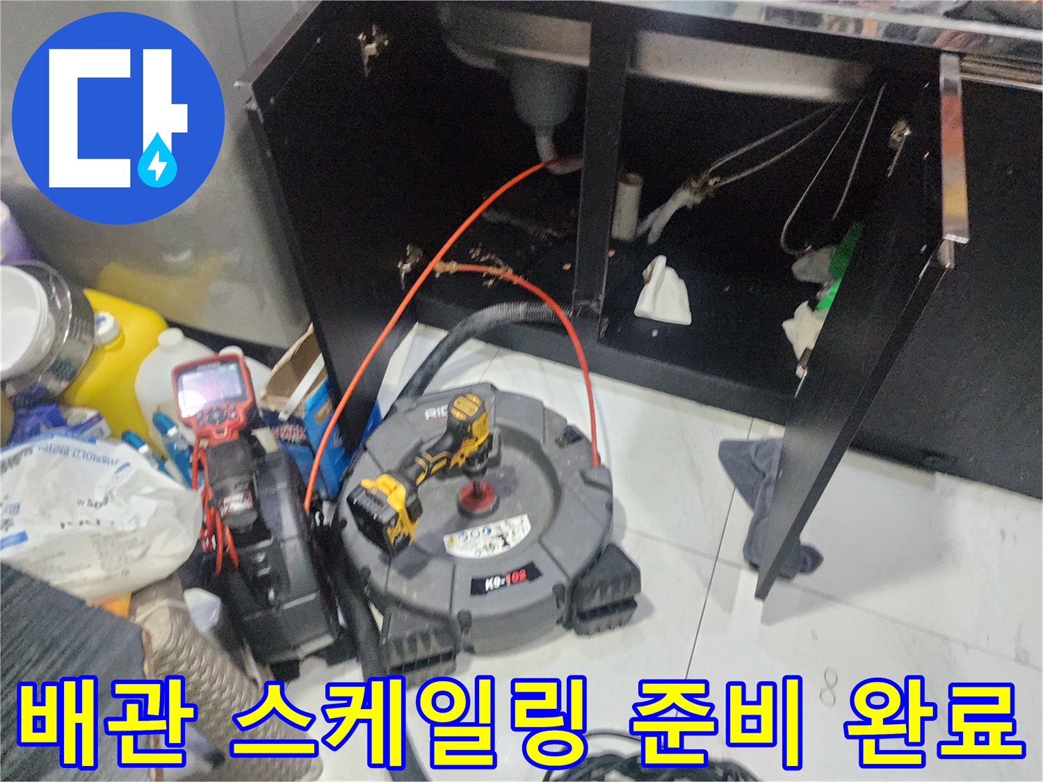싱크대 아래쪽 막힌 하수구를 뚫기 위해 세팅된 내시경 및 스케일링 장비들