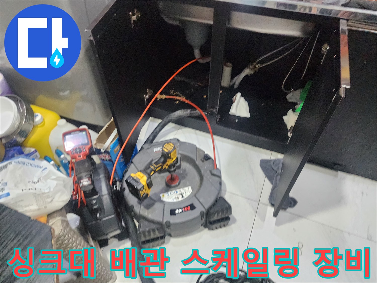 싱크대 하부장 아래 배치된 배관 점검용 내시경 및 측정 도구 세트