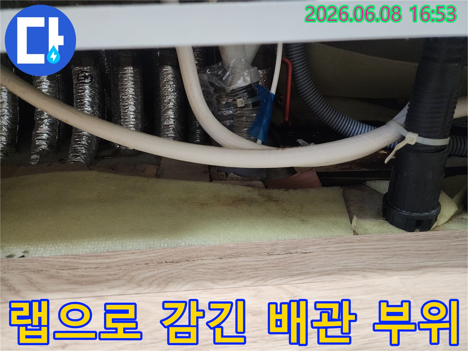 누수를 막기 위해-랩과 타이로 고정된 싱크대 배관 연결부입니다.