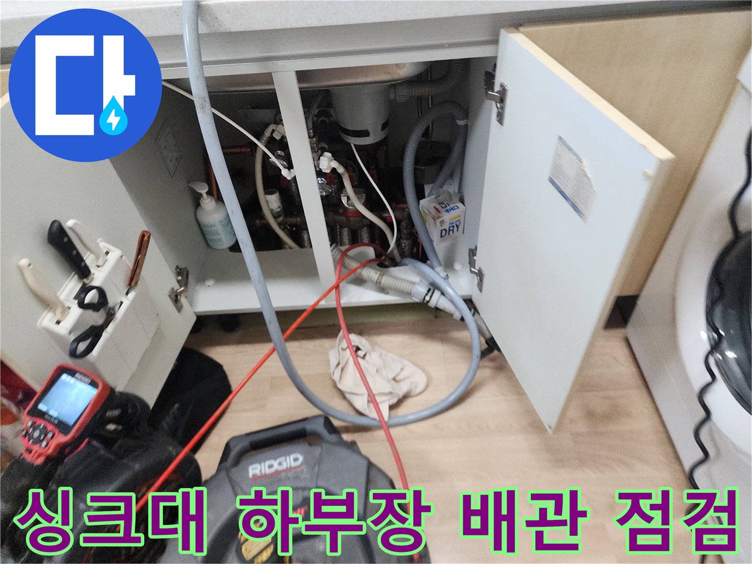 복잡하게 얽힌 싱크대 하부 배관과 작업용 전동 장비의 배치 상태