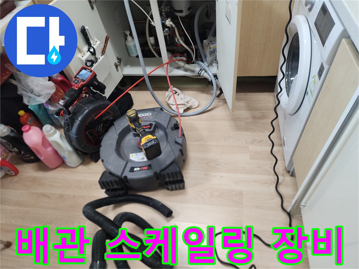 싱크대 아래 배관 스케일링을 위해 설치된 전동 스프링 장비 모습