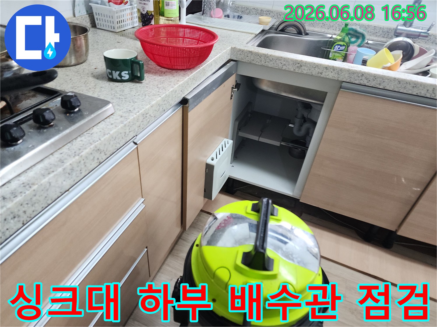 싱크대 하단 배수 배관과 작업용 석션 장비의 모습입니다.