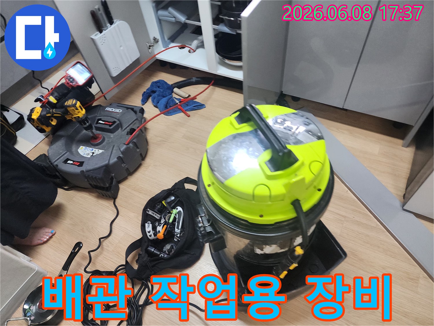 싱크대 배관 스케일링을 위해 배치된 석션기와 전동 도구