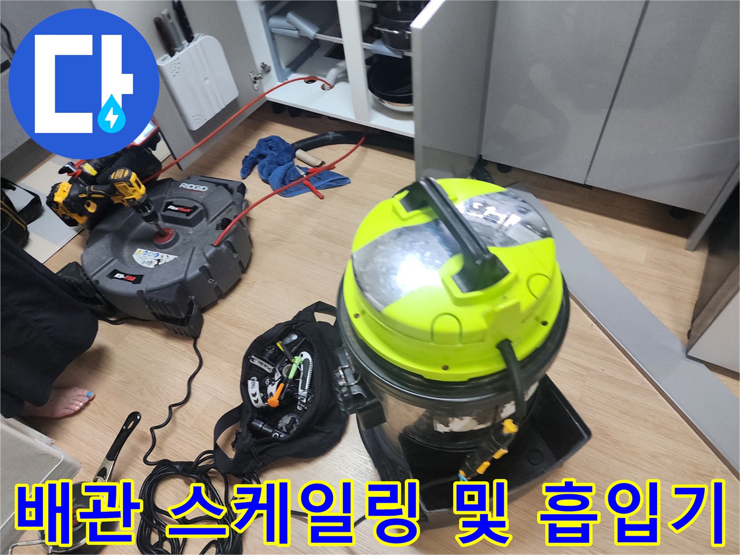 싱크대 하부 배관 청소를 위해 배치된 전문 스케일링 장비와 집진기