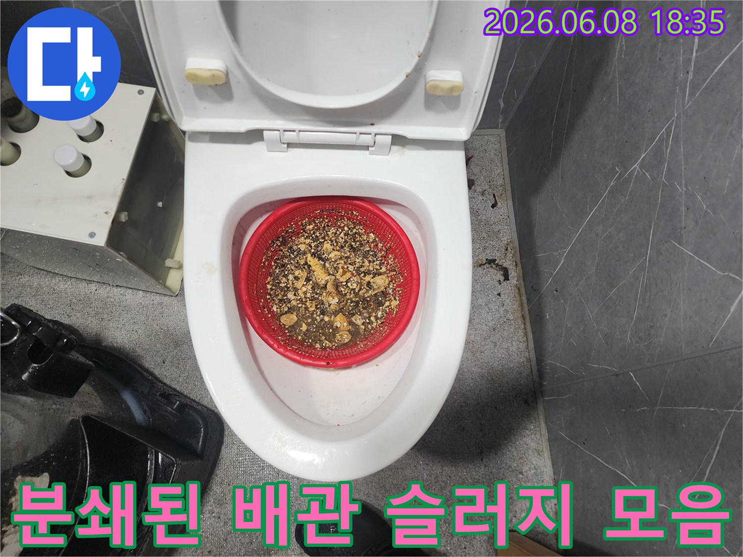 빨간색 거름망에 가득 담겨 있는 배관 스케일링 후의 오물 찌꺼기들
