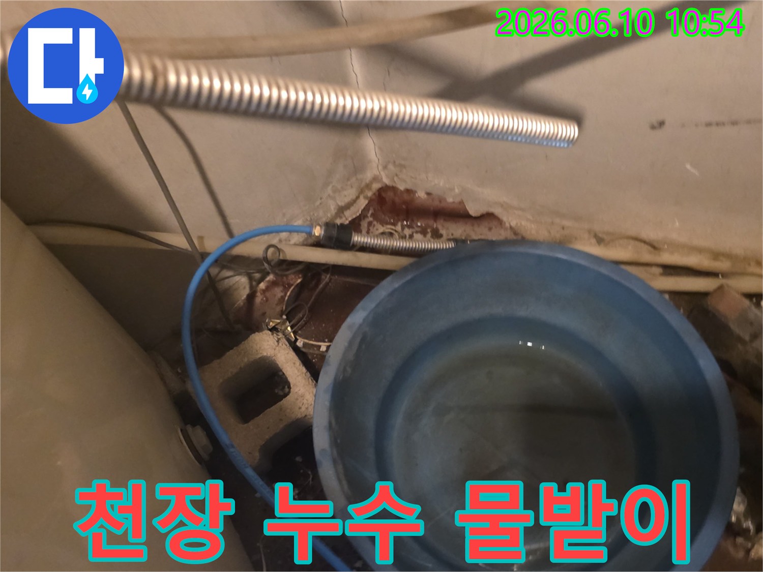 천장에서 물이 새어-파란 양동이로 물을 받는-누수 현장 이미지