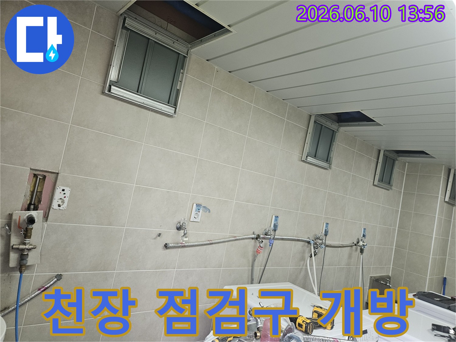 세탁실 천장의 점검구들을 안전하게 개방하여-누수 탐지를 위한 준비를 마친-작업 현장의 모습