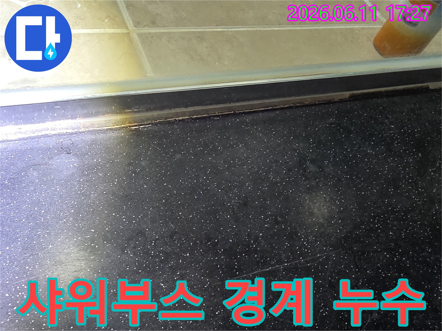 욕실 샤워부스 하단-경계면에서 발생한 물샘과 오염 흔적을 상세하게 보여주는 사진