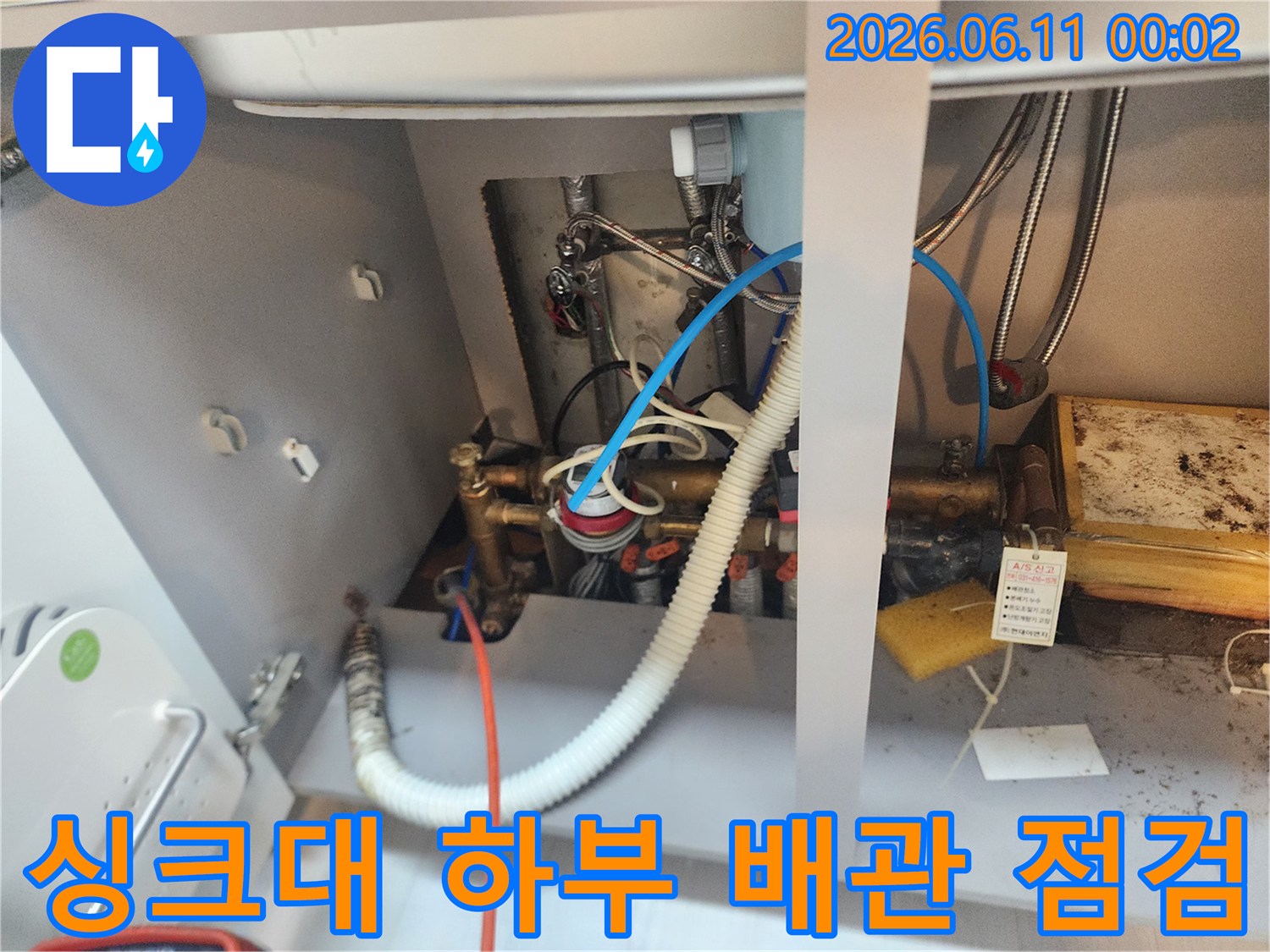 복잡한 싱크대 하부 배관 구조와 스케일링 작업 중인 장비들