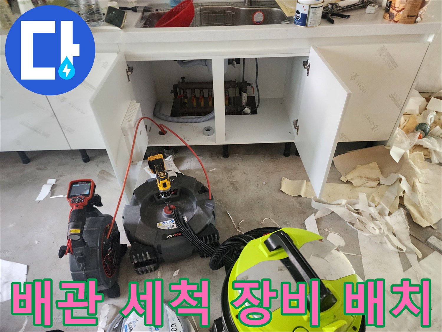 싱크대 하부 배관의 막힌 부분을 뚫기 위해 준비된 전문 청소 장비들입니다.