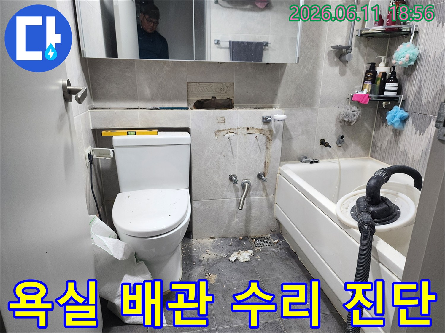 이 이미지는-동대문구 아파트 욕실에서-배관 누수 문제를 해결하기 위해-타일을 제거하고-손상된 배관의 상태를-정밀하게 진단하는-작업 현장을 보여줍니다