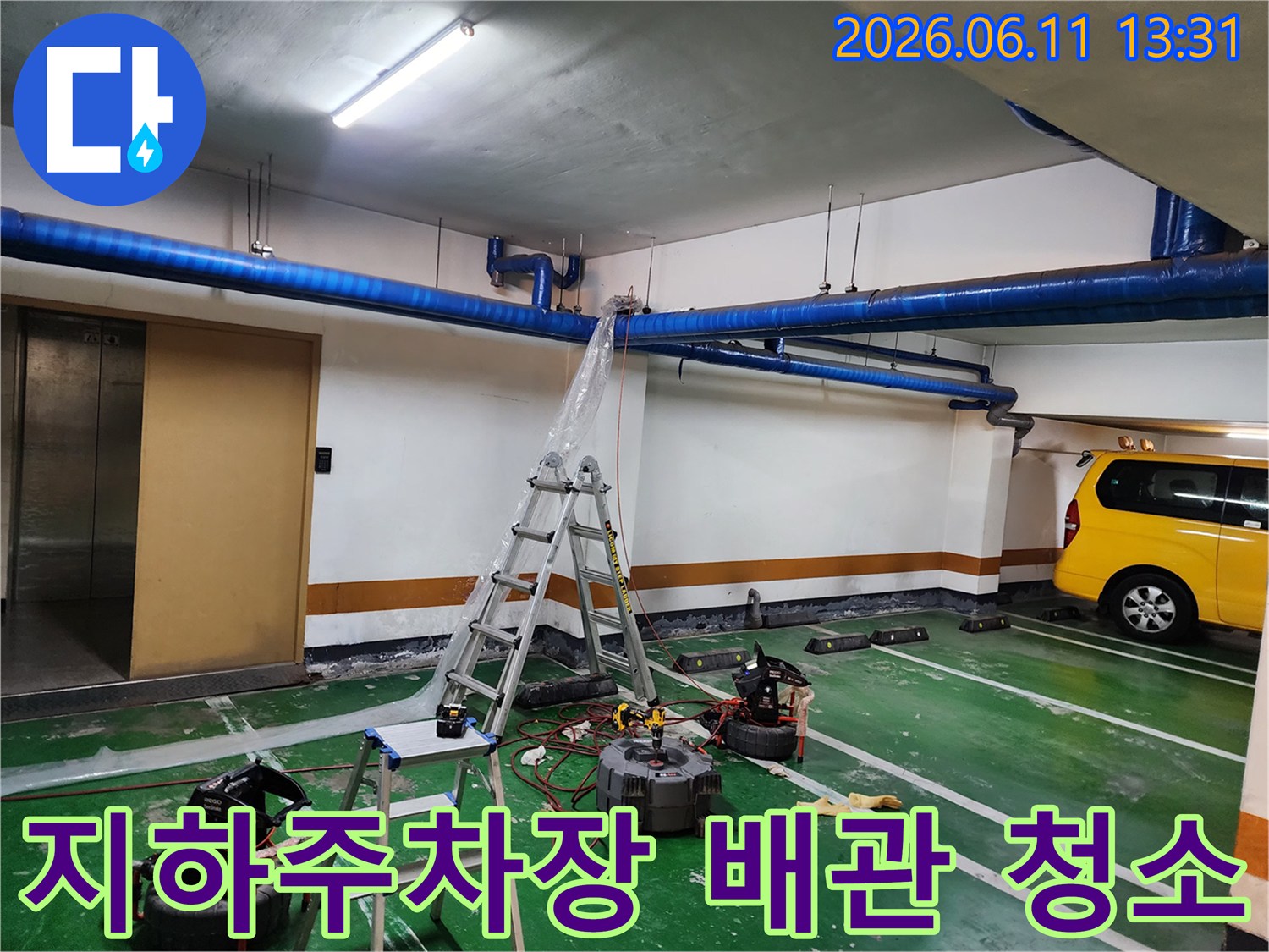 파란색 공용 배관이 지나가는-지하 주차장 내부 작업 현장