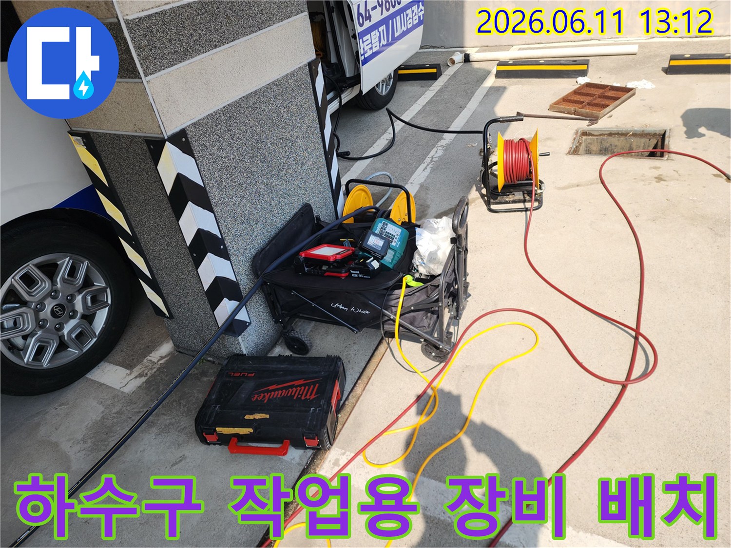 건물 기둥 옆에 설치된 배관 청소용 릴과 밀튼 공구 상자