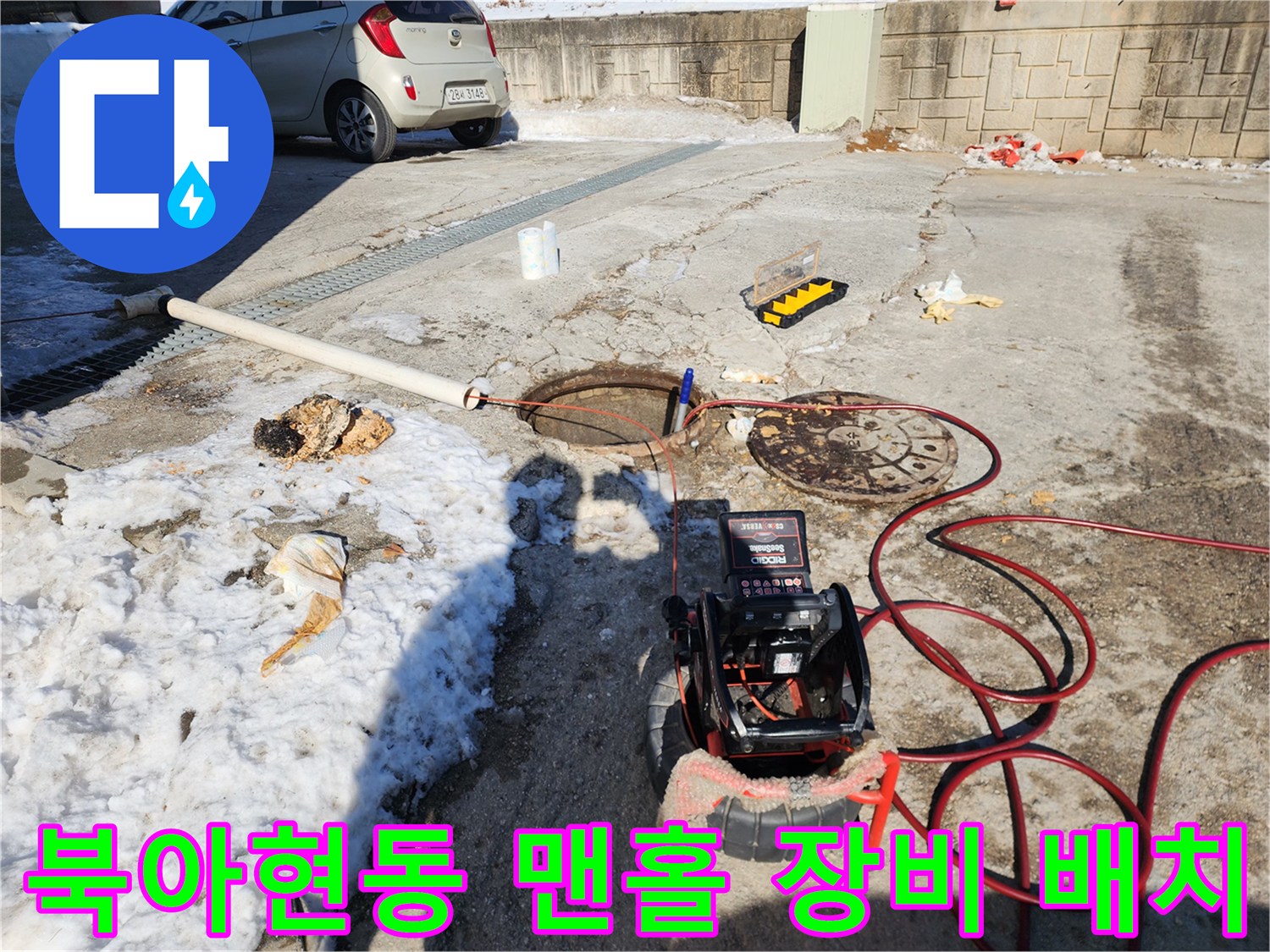 맨홀 주변에 준비된 고압 세척 호스와 모니터링 장치