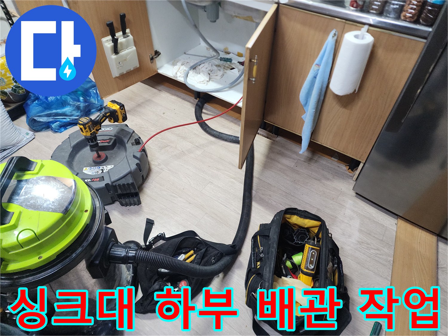 싱크대 하단 배관 청소를 위해 세팅된 석션기와 공구들