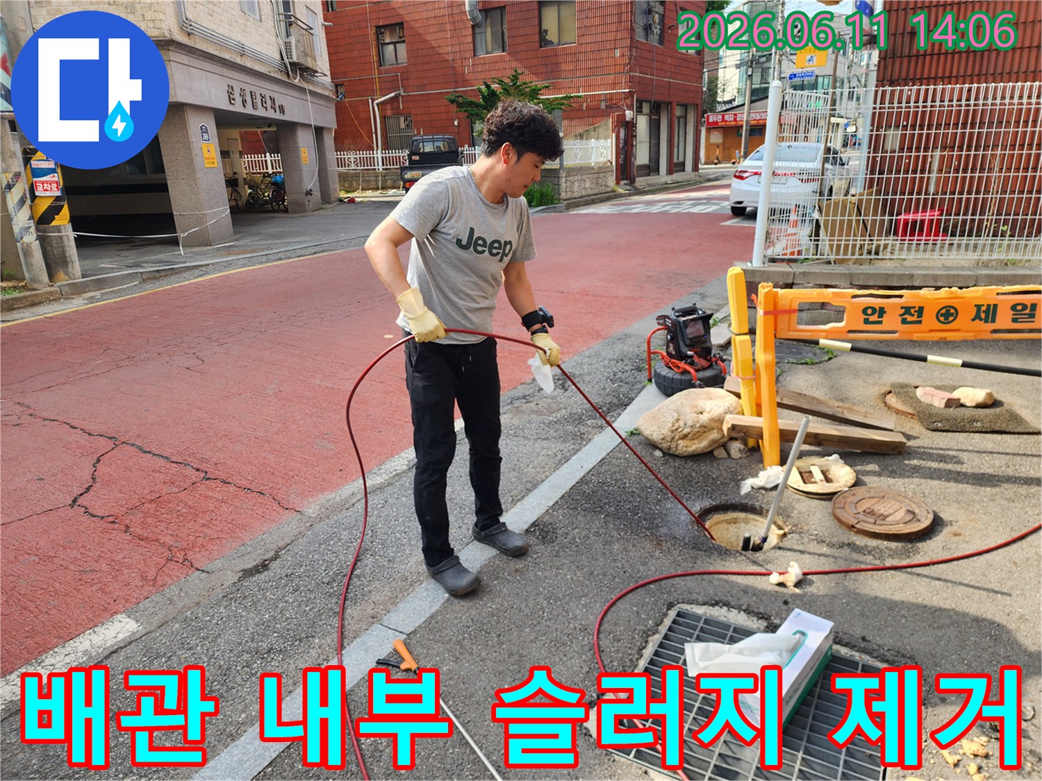 맨홀 하수 배관의 막힌 부분을 뚫기 위해 세척 중인 작업 현장
