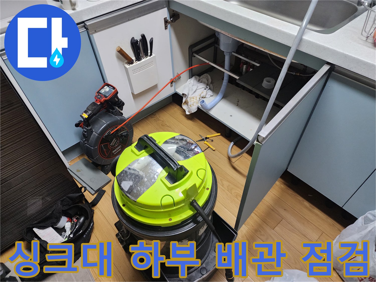 싱크대-하부-공간에-배치된-전문-청소-장비와-호스
