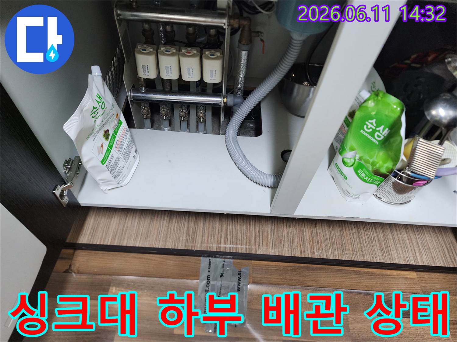 성북구 장위동 싱크대 아래쪽의 복잡한 배관과 정수기 연결 호스 모습