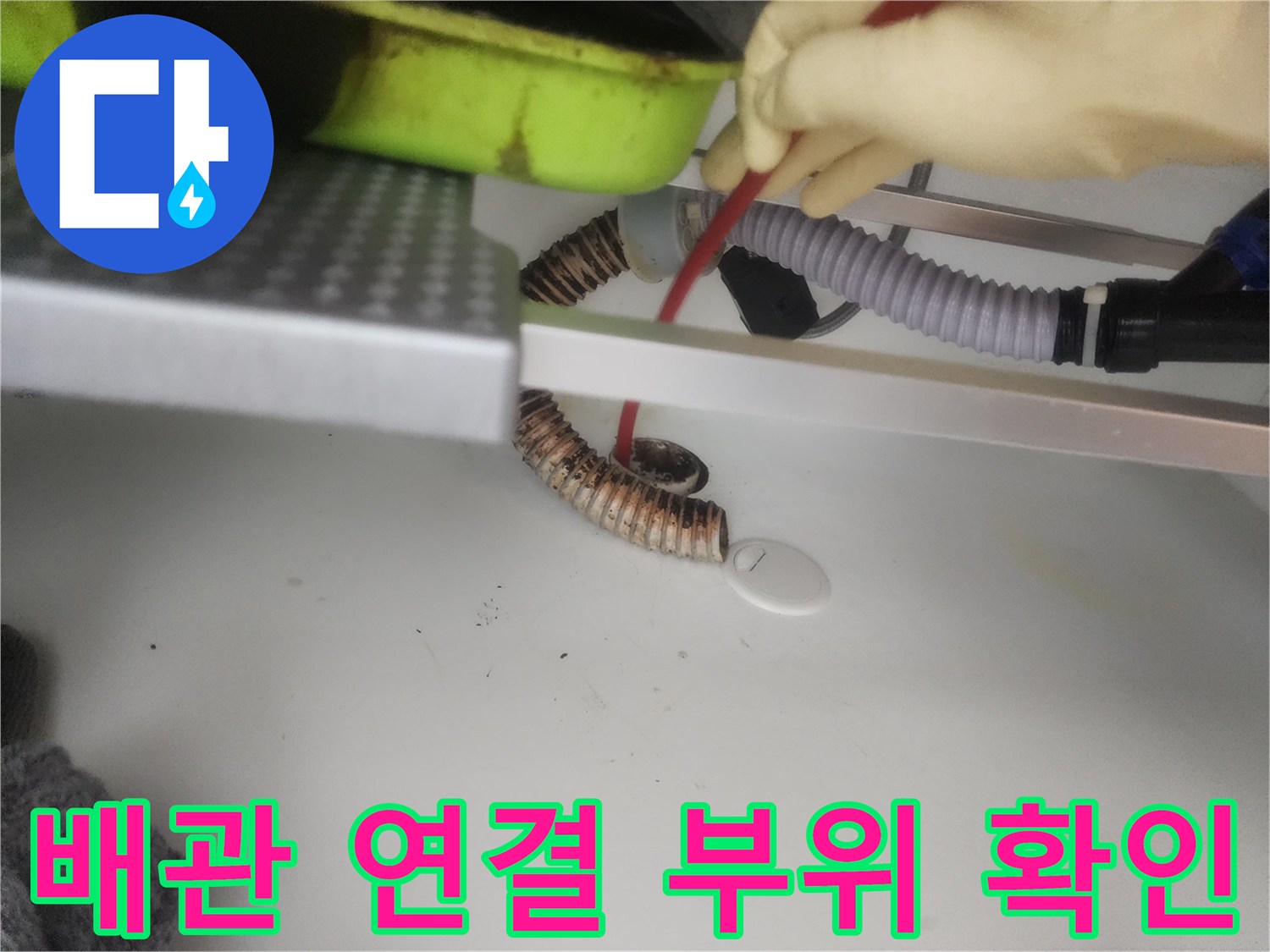 주방 싱크대 하부의 굴곡진 배수 호스와 유연한 관 구조