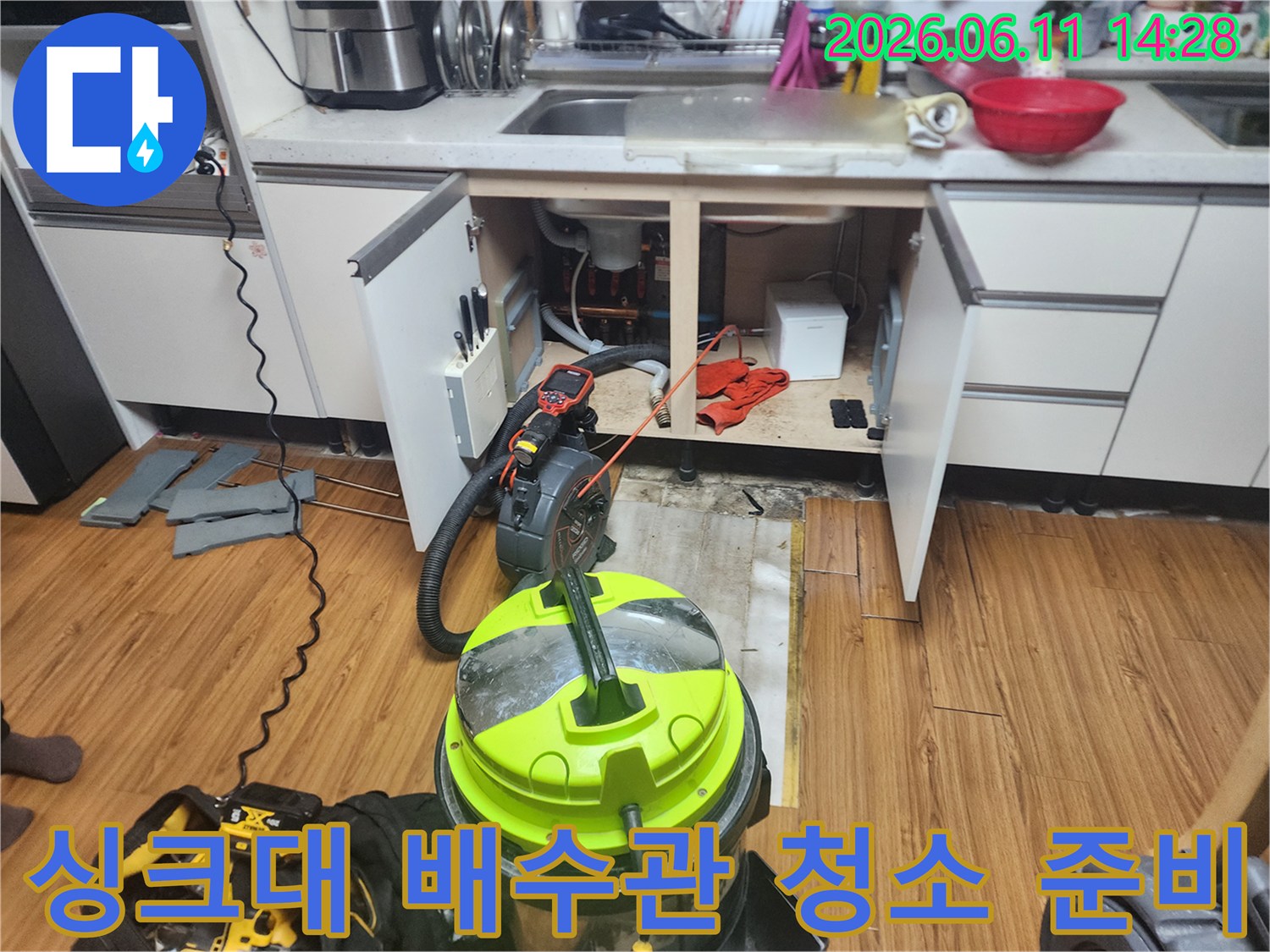 석션기와 각종 장비가 배치된 싱크대 하부 작업 현장