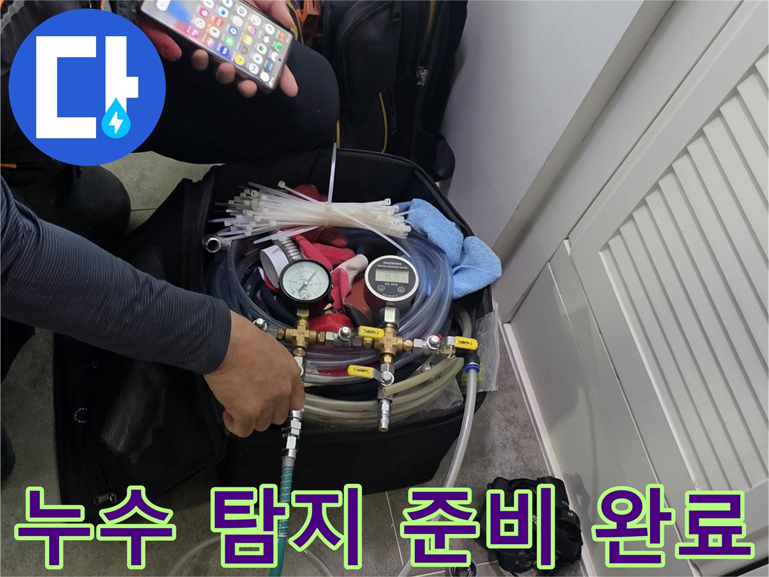 현장에서 누수 탐지 장비를-조작하며-스마트폰으로 데이터를 분석하는 엔지니어