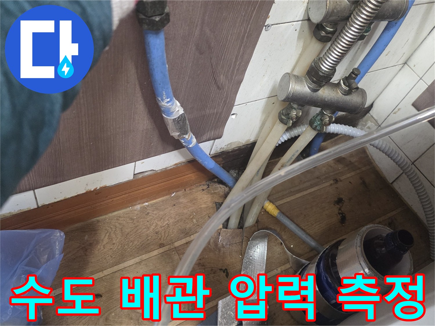 싱크대 아래 수도 배관에 연결된 공압 테스트 장비와 호스 상태