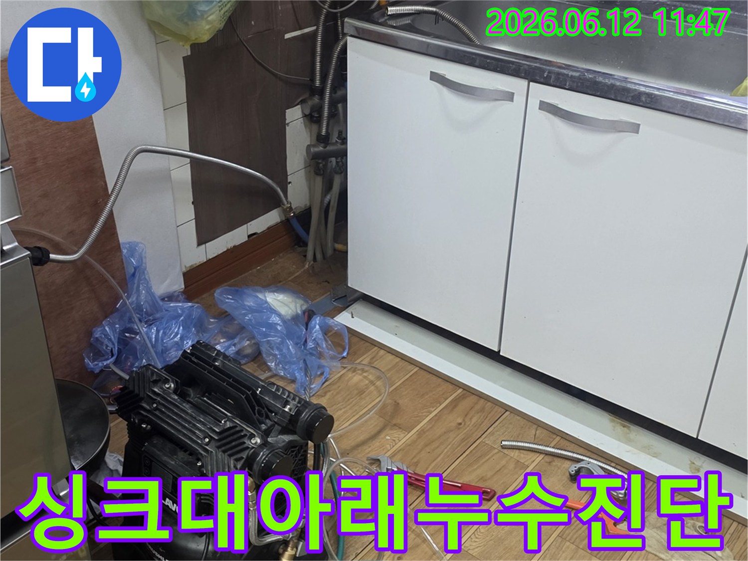 싱크대 하부 공간에서-누수 문제를 진단하기 위해-전문 장비를 연결하고-점검하는 엔지니어의 모습
