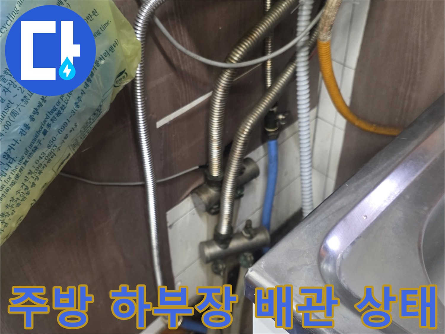 싱크대-하부장-아래-복잡하게-연결된-금속-배관-및-수도-연결부-모습