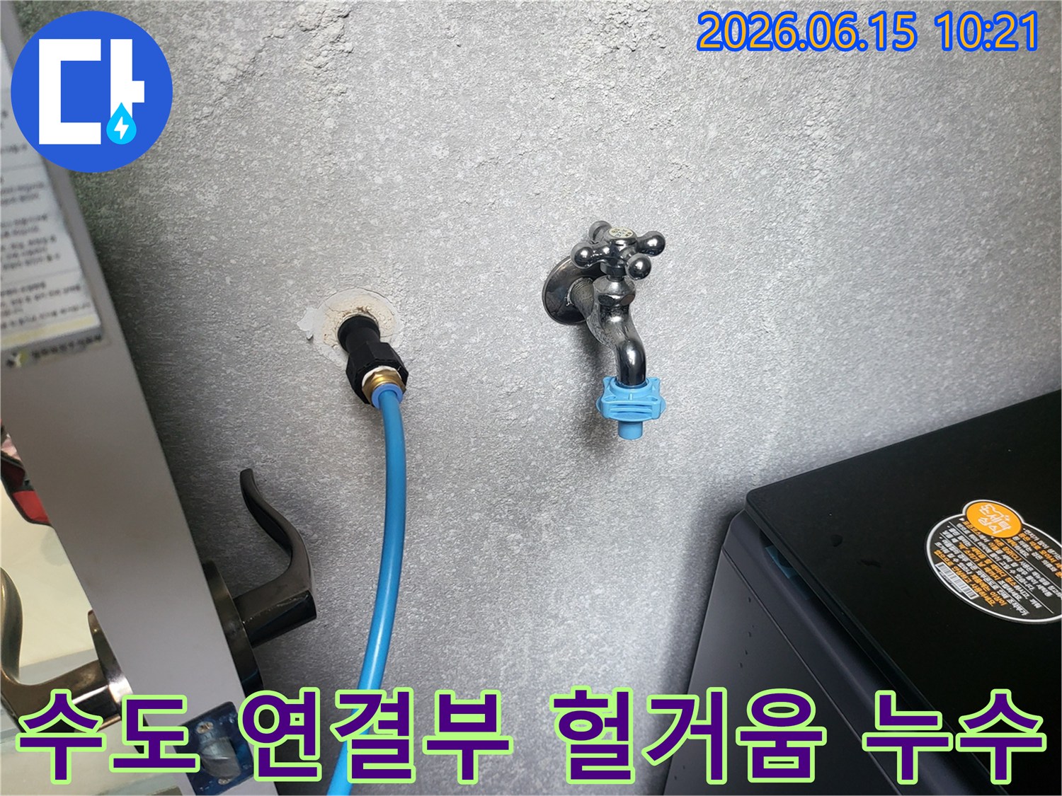 회색 벽에 연결된 수도 호스-헐거워진 연결 부위를 점검하고 재조임하는 모습