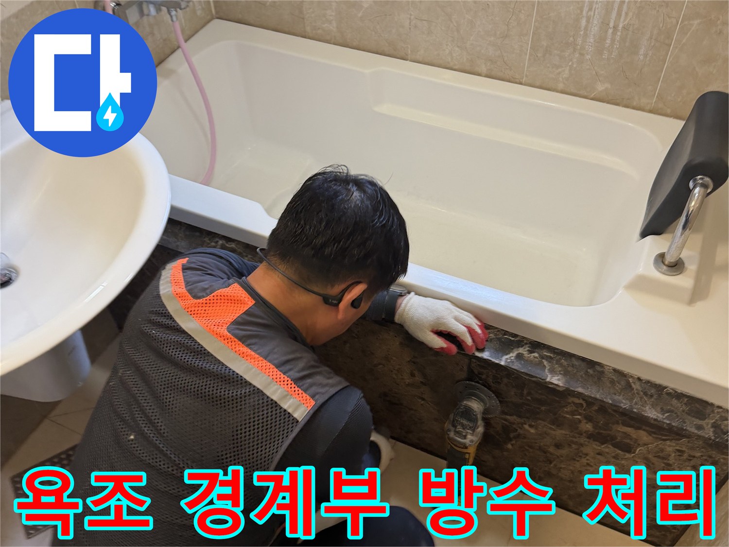 검은색 대리석 마감재와 흰색 욕조 사이의 누수 지점 보강 작업 현장