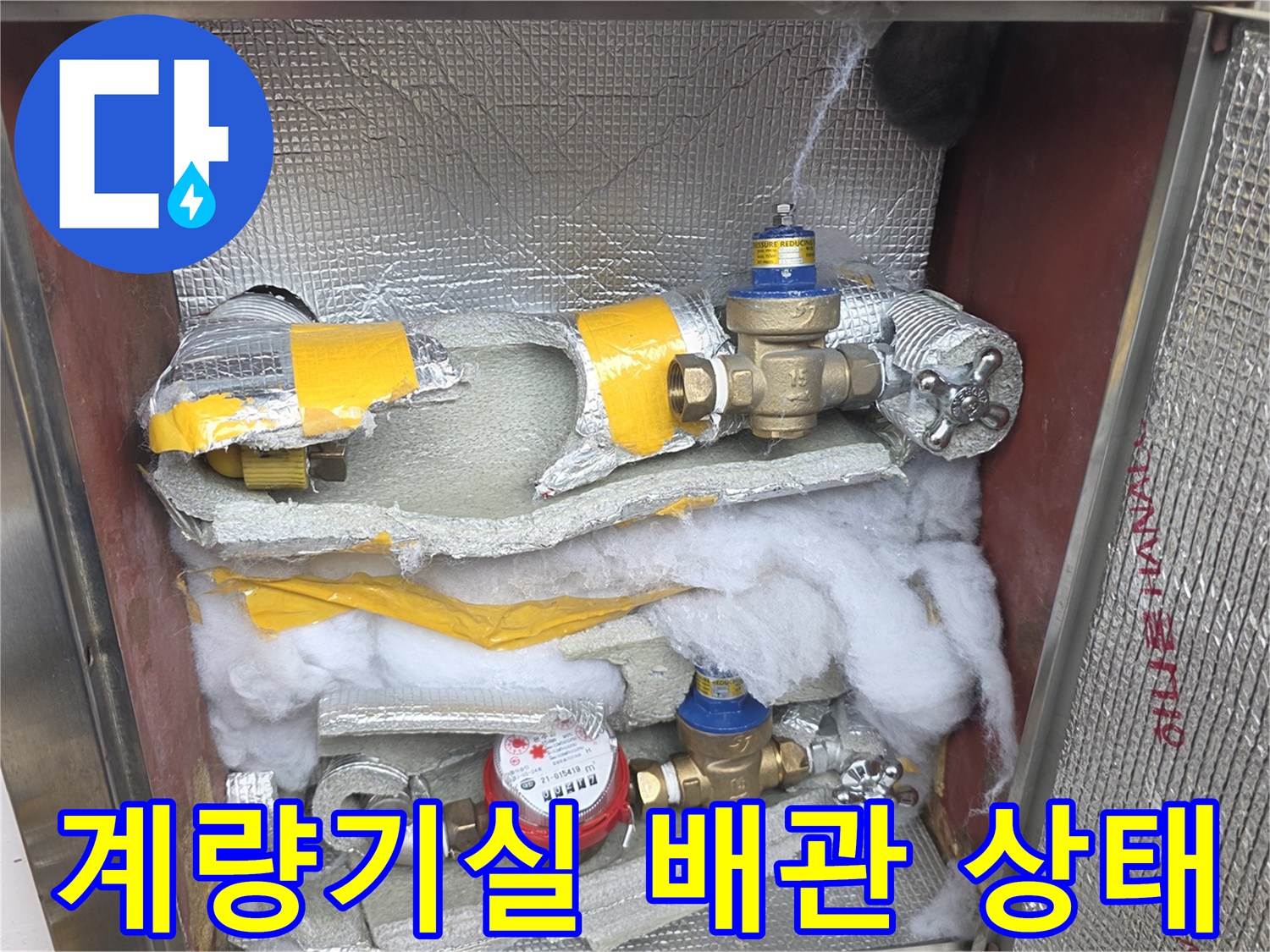 수도 계량기와 온수 공급용 배관이 설치된 내부 모습입니다