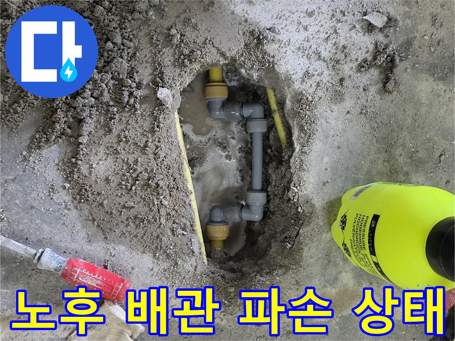 흙을 걷어낸 뒤 드러난 손상된 온수 배관과 작업 도구들