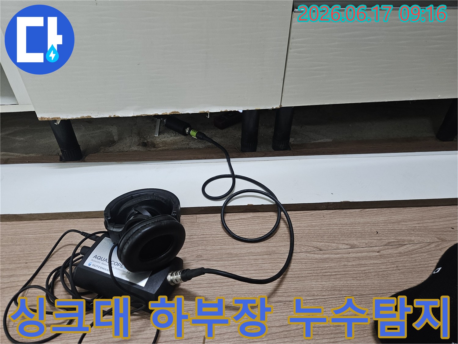 싱크대 하부장 아래에서 누수음을 정밀하게 청음하여 누수 지점을 찾는 모습