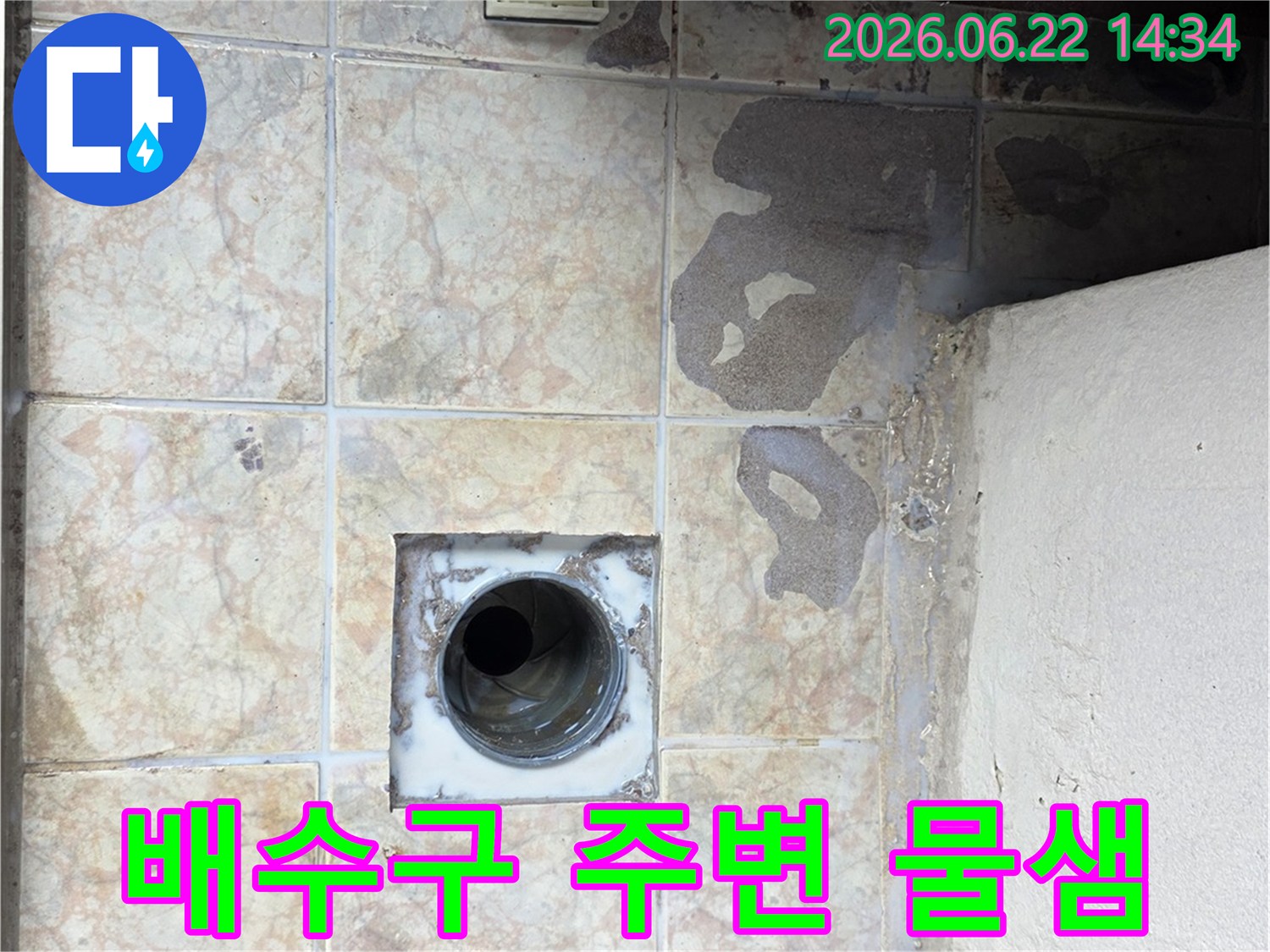 배수구-주변에서-발생한-물샘으로-인한-타일의-변색과-손상을-기록한-이미지