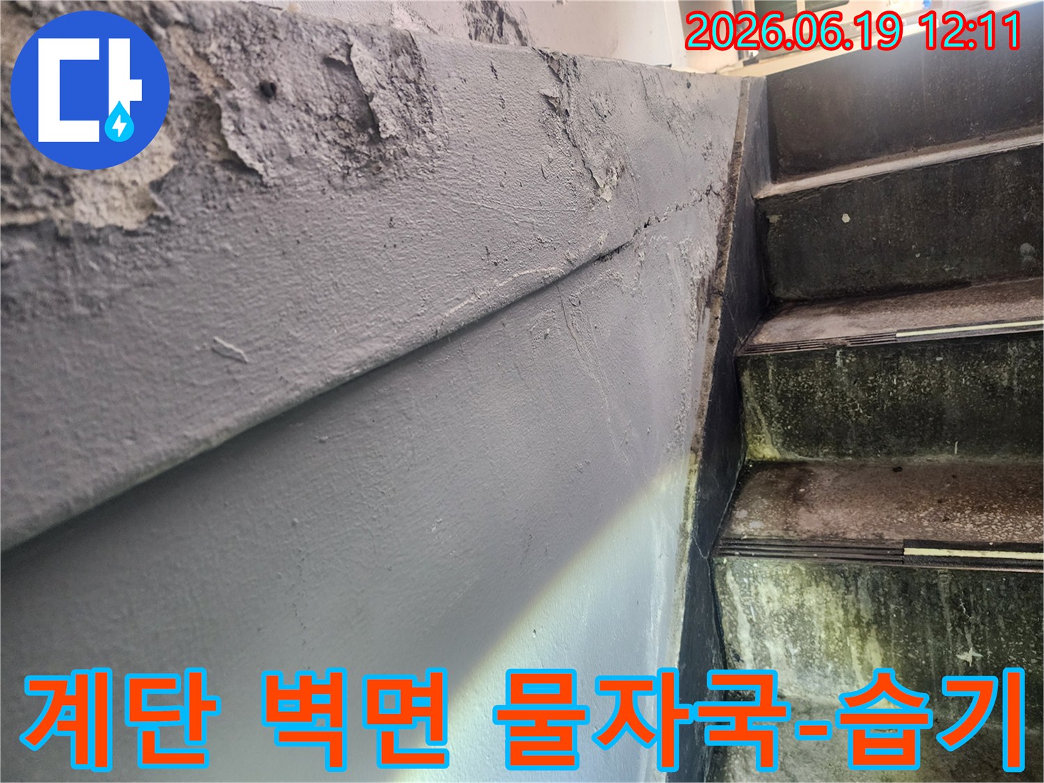 계단 옆 벽면에 물이 스며들어 페인트가 벗겨진 모습-습기로 인한 벽면의 얼룩과 손상-누수 문제로 인한 건물 내부 환경 저해
