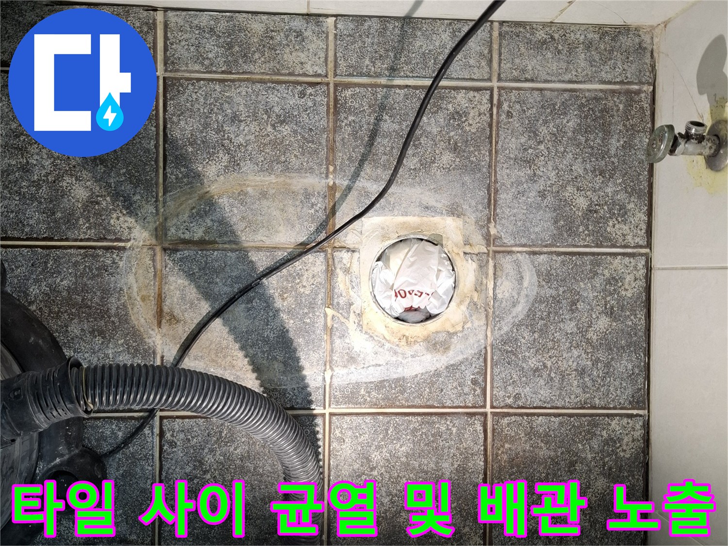 욕실-배수구-주변의-깨진-타일과-노출된-배관-연결부