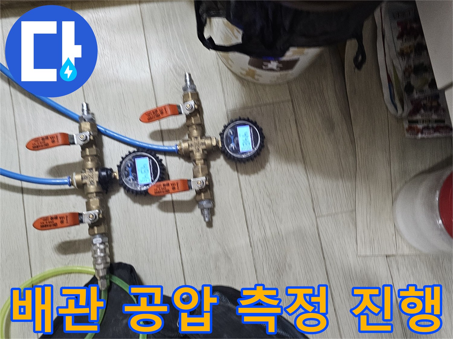 배관에 연결된 압력 게이지와 파란색 점검용 호스들