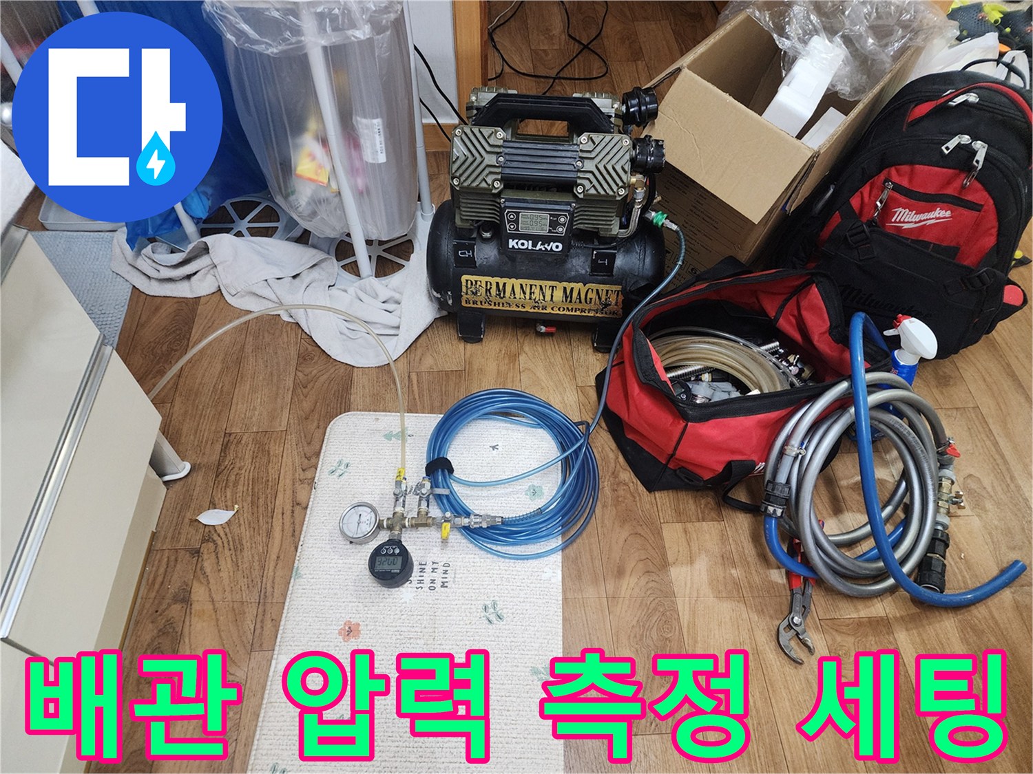 배관 내부의 공기압을 측정하기 위해 연결된 게이지와 콤프레샤 장비