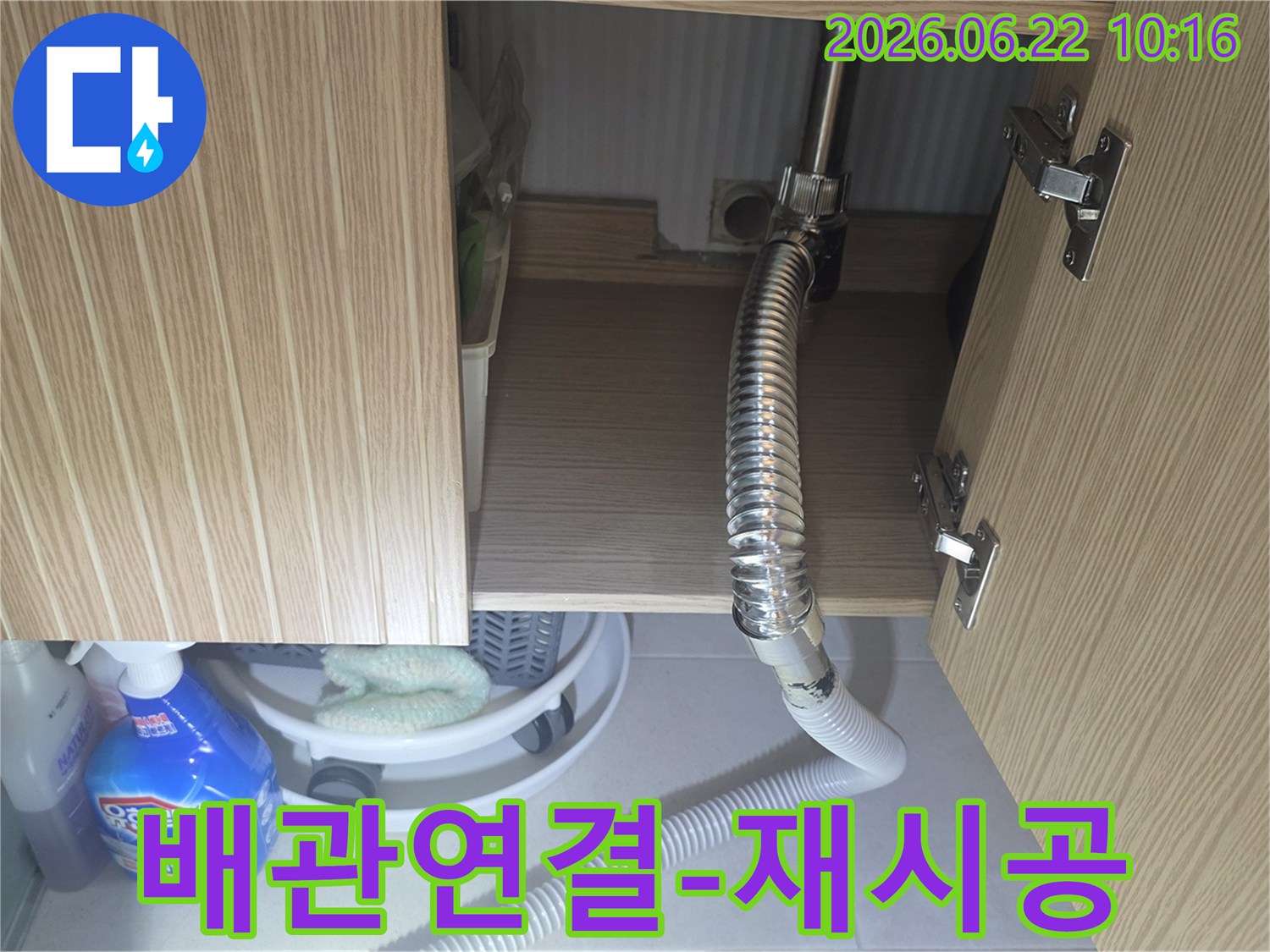 싱크대 하부장 내부의 배관 연결 부위를 점검하고 재시공을 준비하는 모습