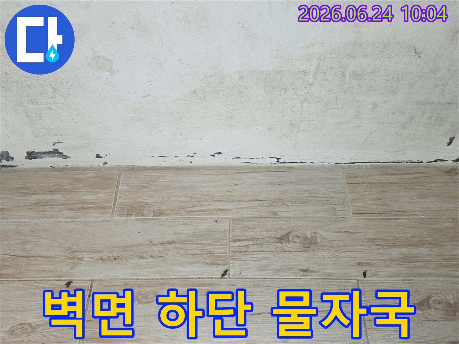 벽면-하단에-선명하게-남아있는-물자국과-손상된-페인트를-보여주는-이미지입니다