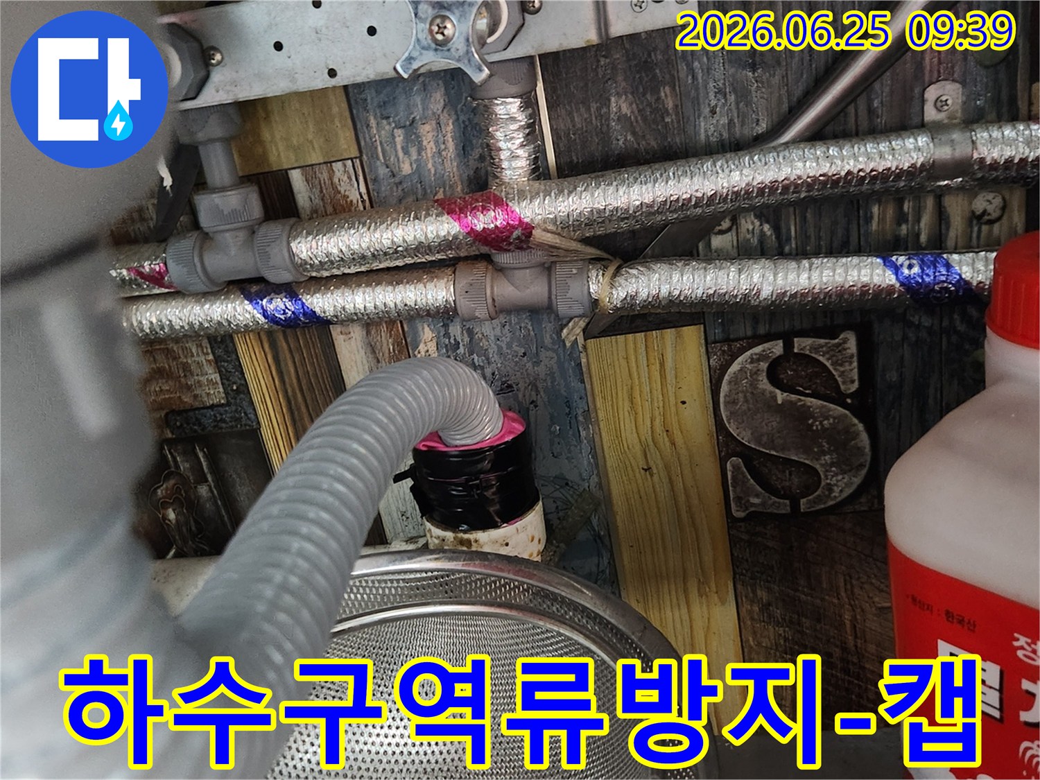 누수 공사 완료 후-세탁실 배수구에서 물이 역류하는 것을 방지하고-위생을 지키기 위해-특수 제작된 하수구 캡을 설치하는 모습