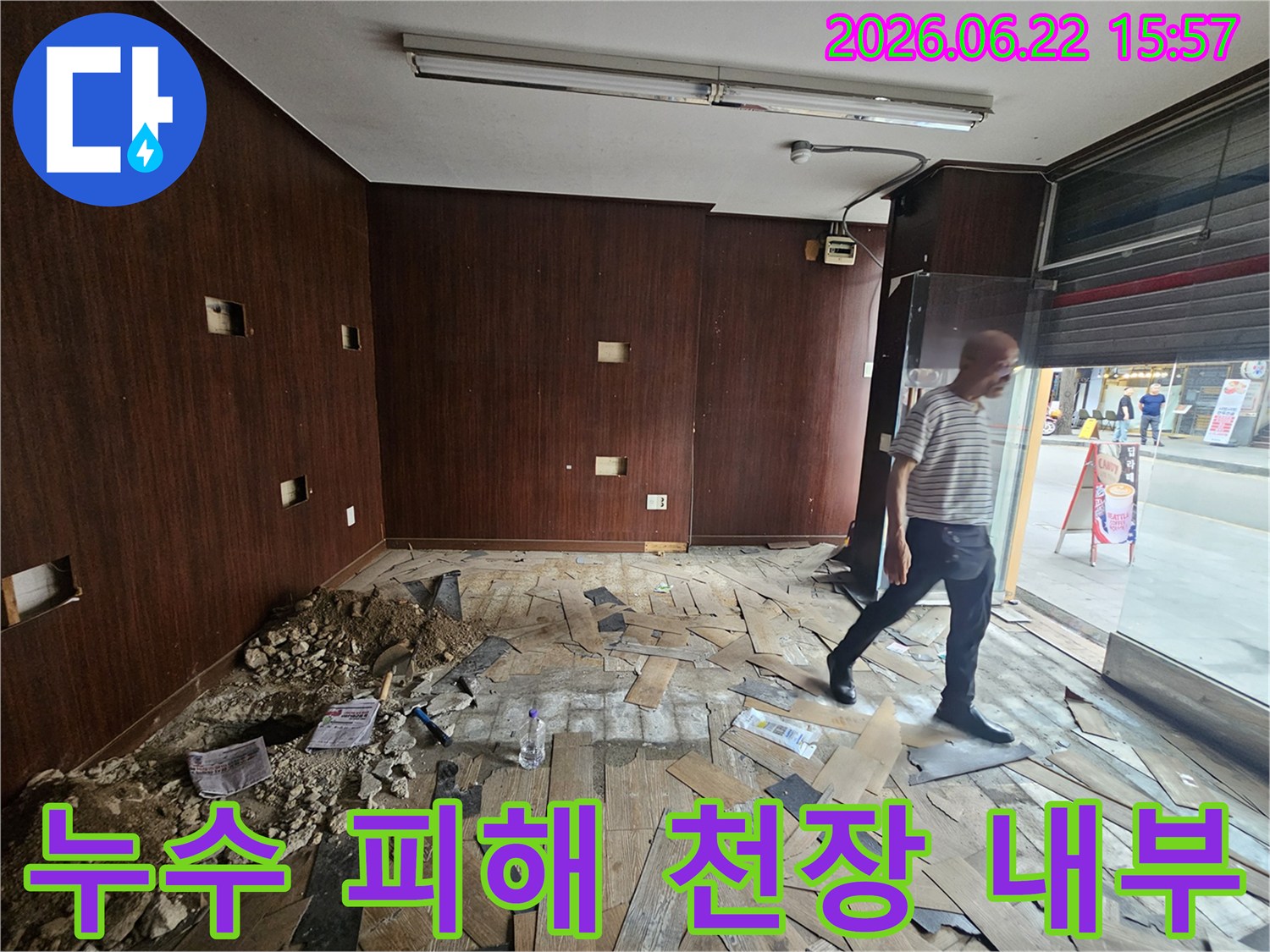천장 누수로 인해-내부 마감재와-구조물이 손상된-상가 건물 내부를-보여주는 이미지입니다-엔지니어가-현장을 면밀히-점검하고 있습니다.