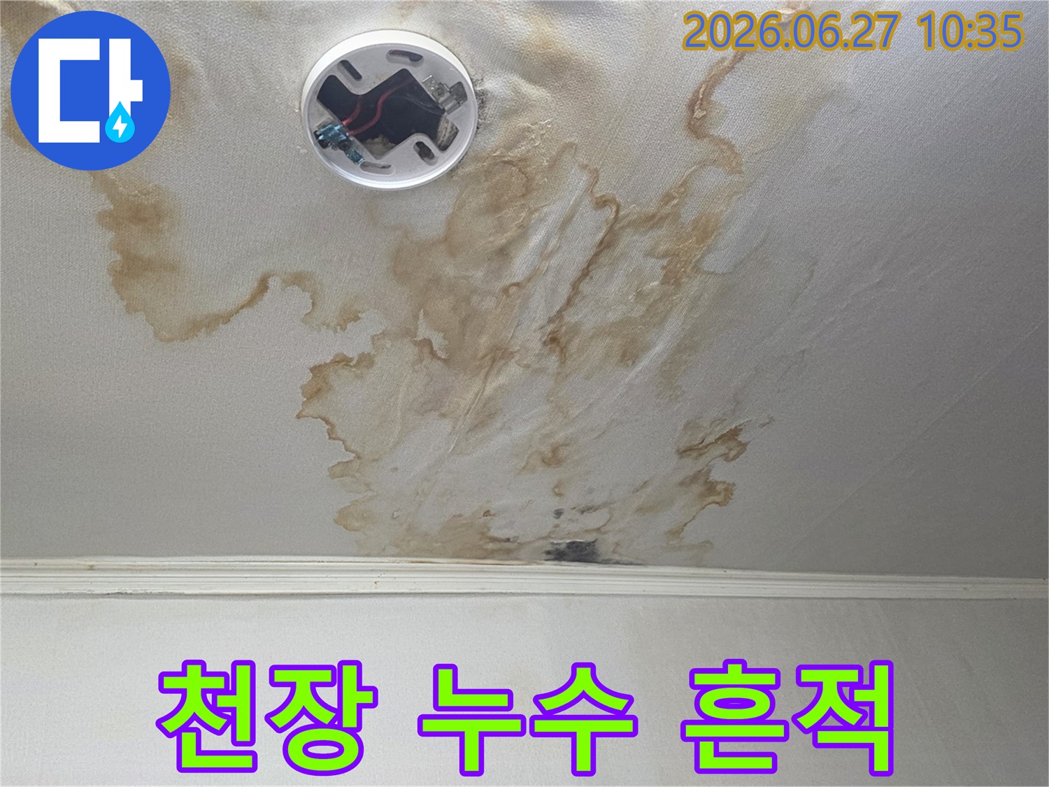 천장 누수로-인한 심각한 물얼룩과-전등 주변의 손상을 보여주는 이미지