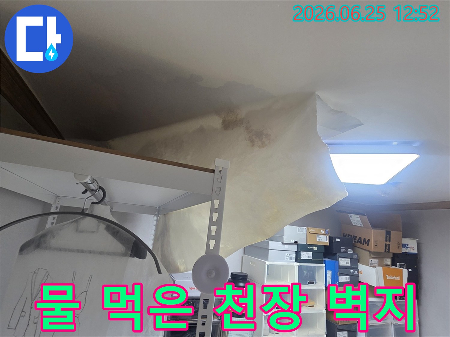 누수로 인한 천장 손상과-벽지 변색이 확연한-주거 공간의 문제점을 명확히 보여줍니다.