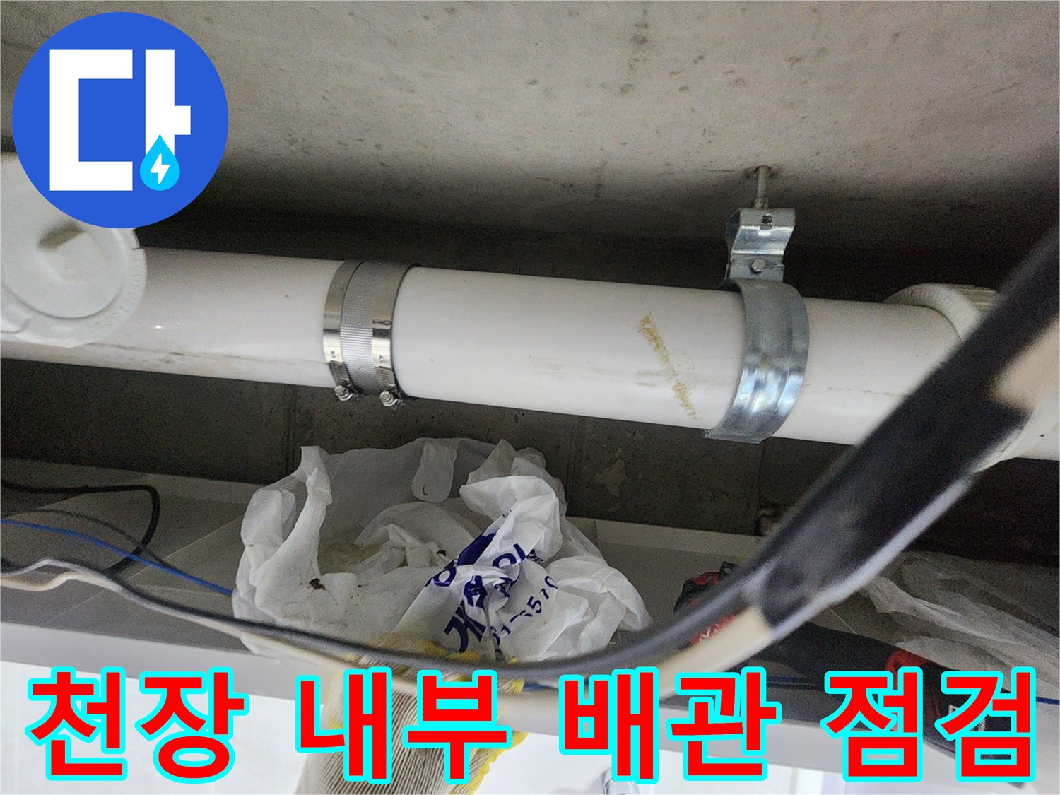 천장 구조물에 설치된 흰색 PVC 배관과 금속 고정 장치