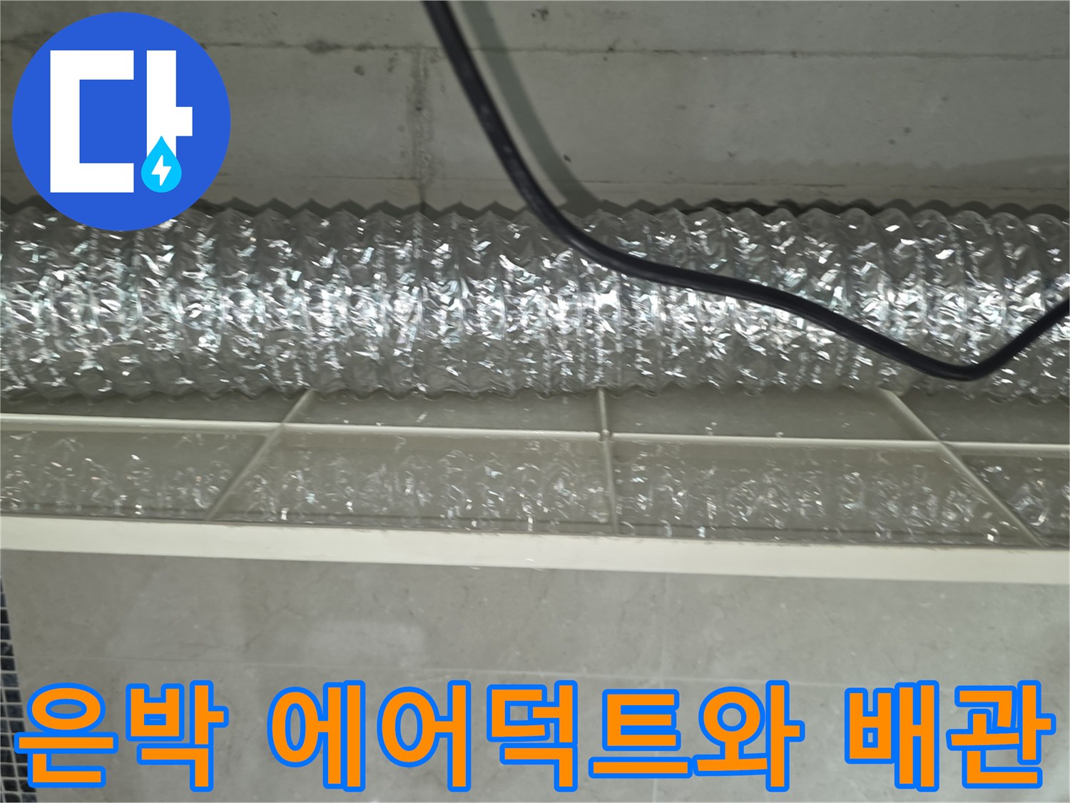 천장 슬래브 아래 설치된 은박 덕트와 급수 배관의 근접 촬영