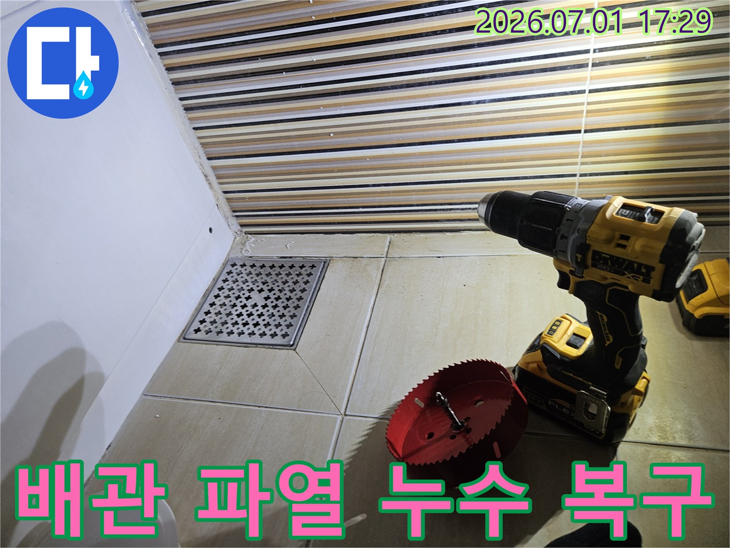 욕실 바닥 배수구 주변에서-배관 파열로 인한 누수를 탐지하고-복구 작업을 위해-드릴과 홀쏘를 준비하는 현장입니다