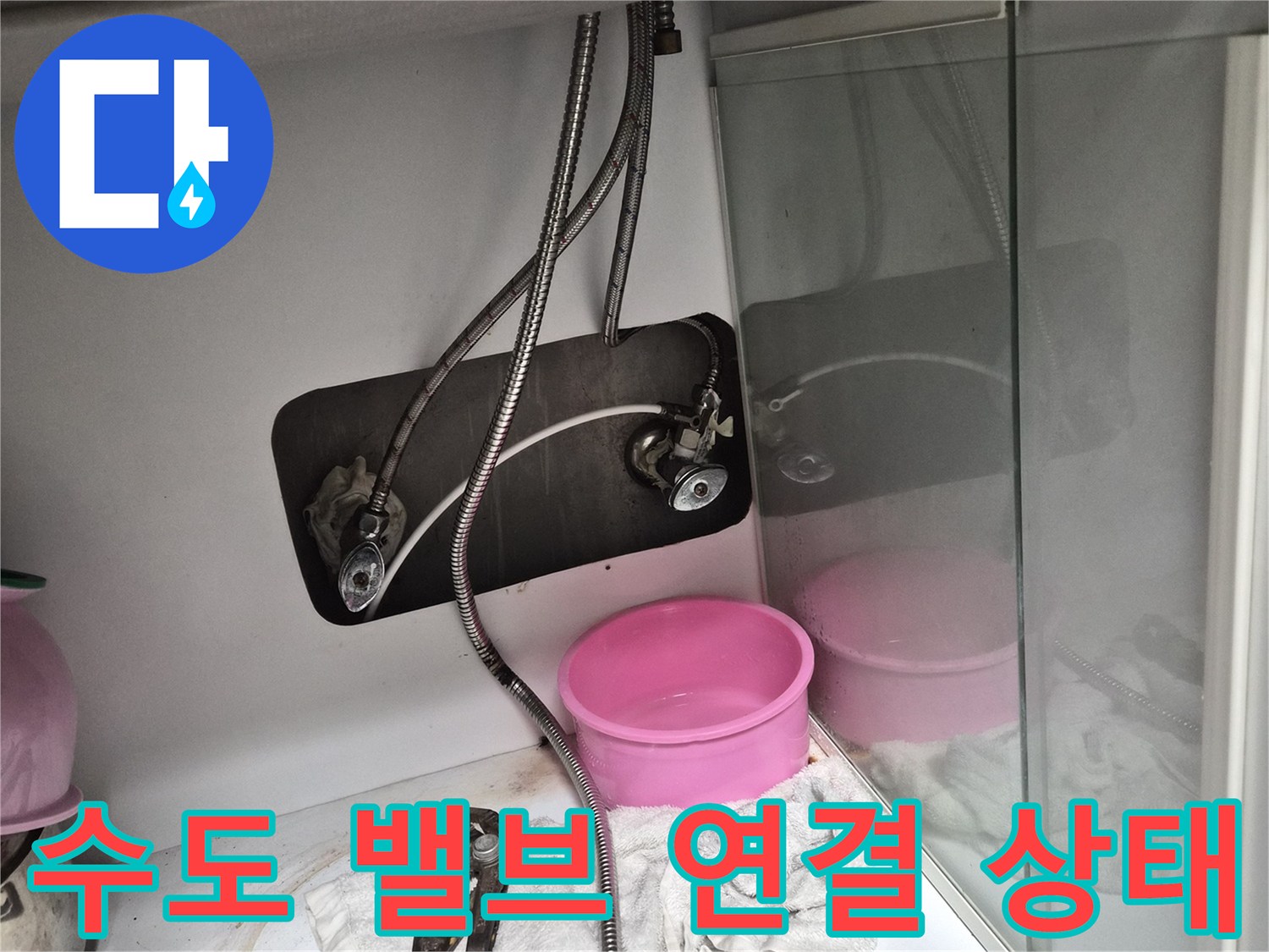 수전 호스와 앵글 밸브가 연결된 싱크대 하부장 내부 모습
