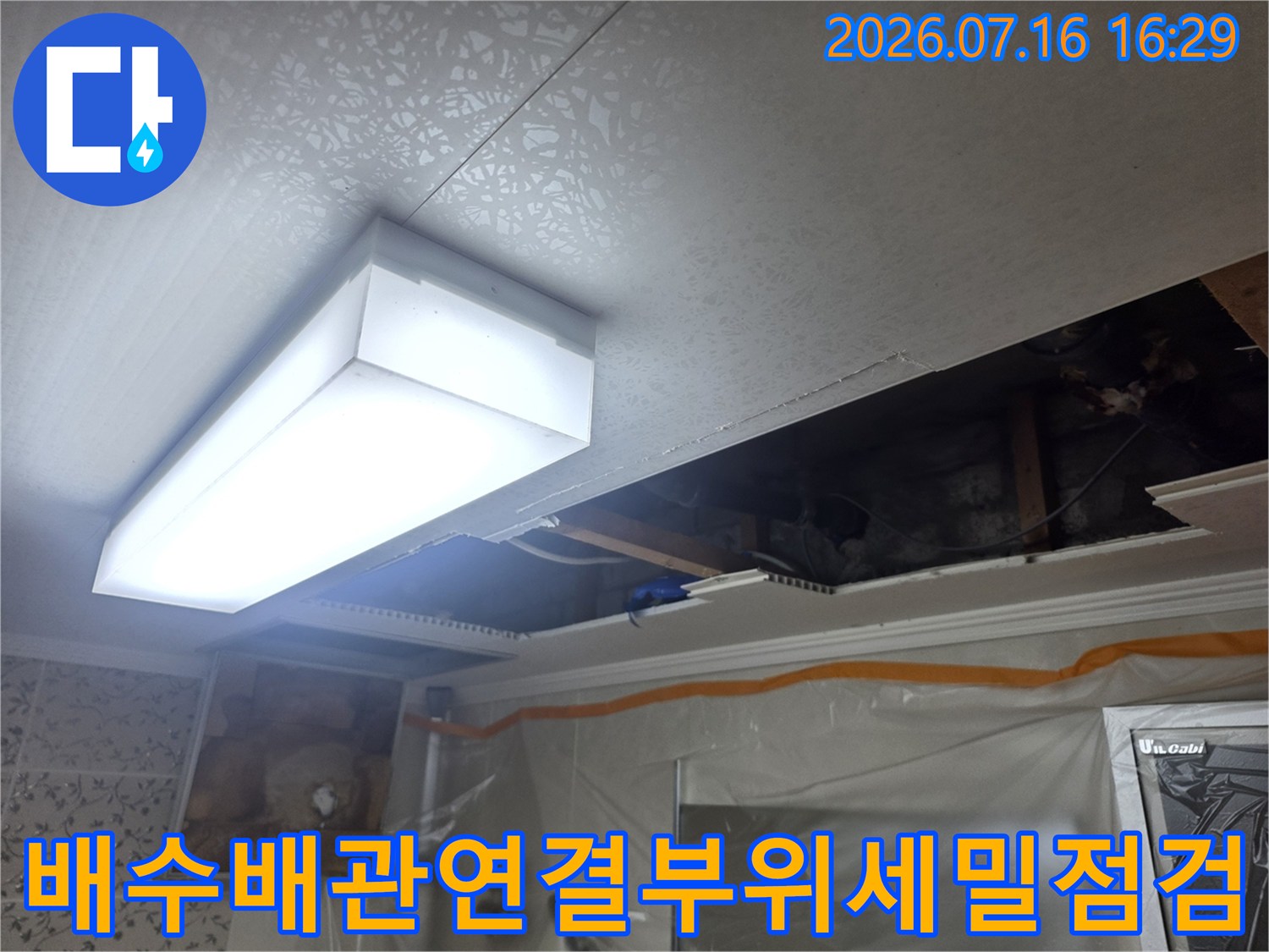 천장 점검구 내 배수 및 오수 배관 연결 상태를 점검하는 장면